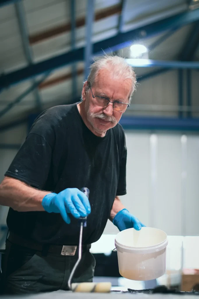 Medewerker met handschoenen bij een werkbank