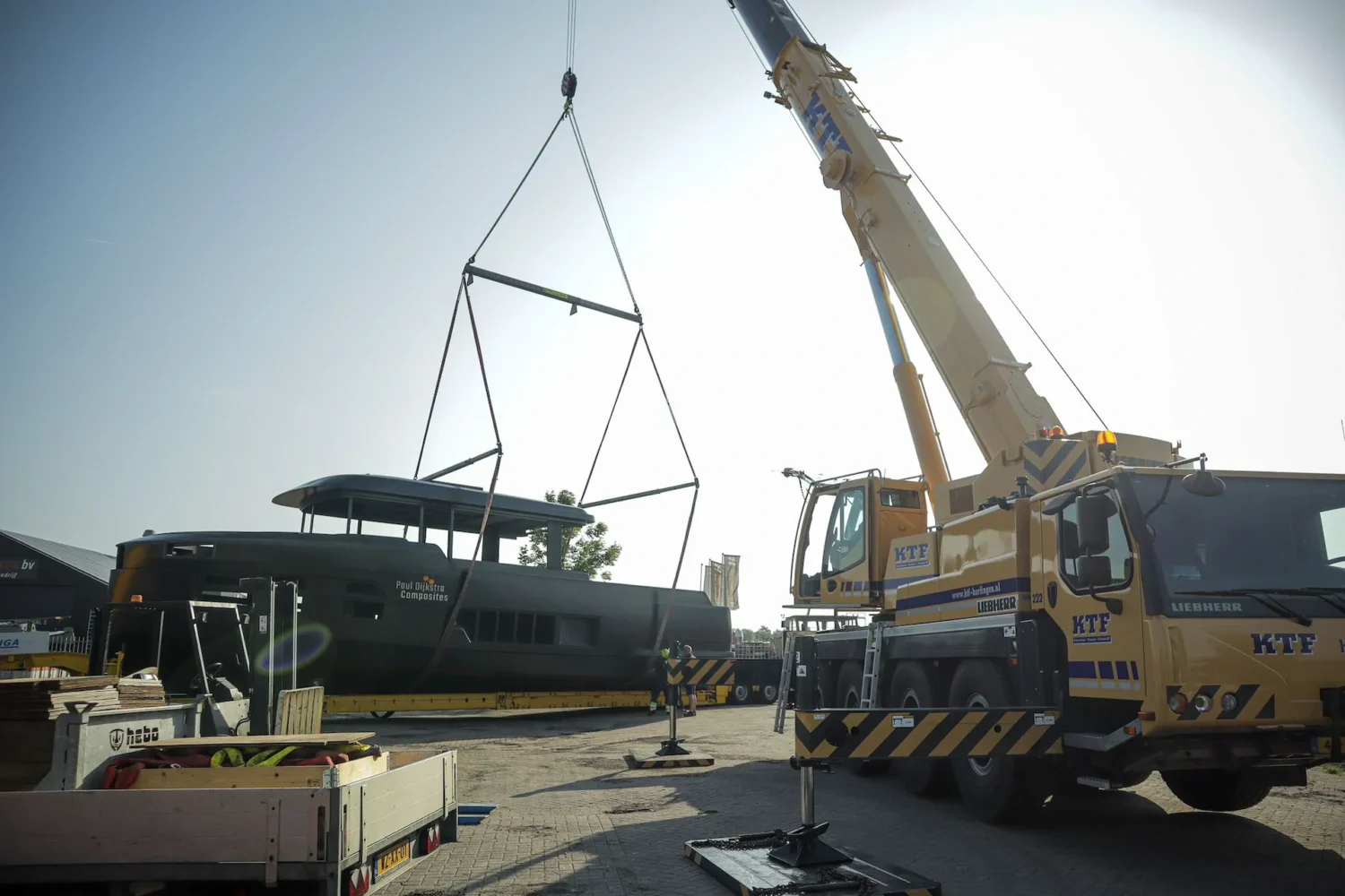 Kraan hijst een jachtopbouw op een bootcasco