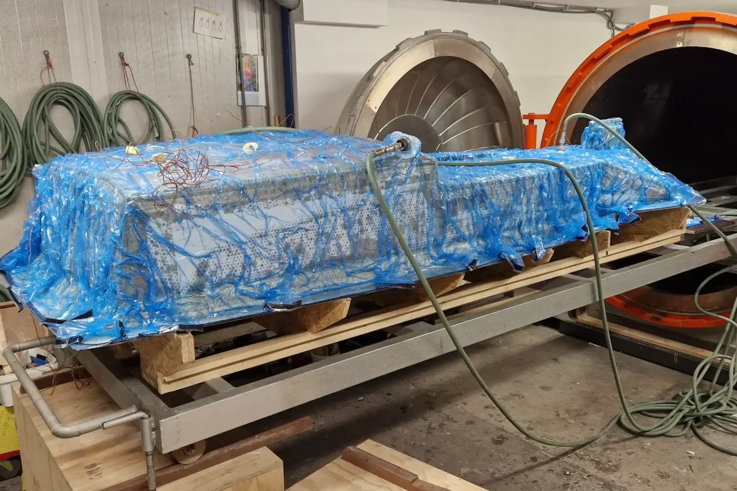 Bootonderdeel onder blauw vacuümfolie op een werkbok