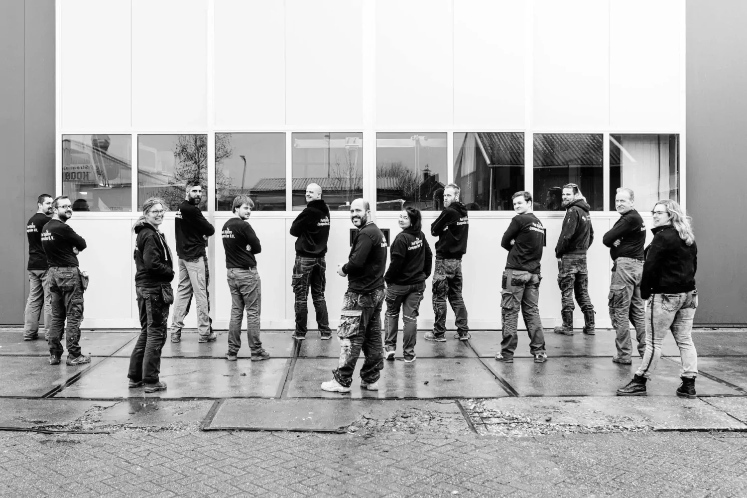 Zwart-witfoto van medewerkers voor de bedrijfshal