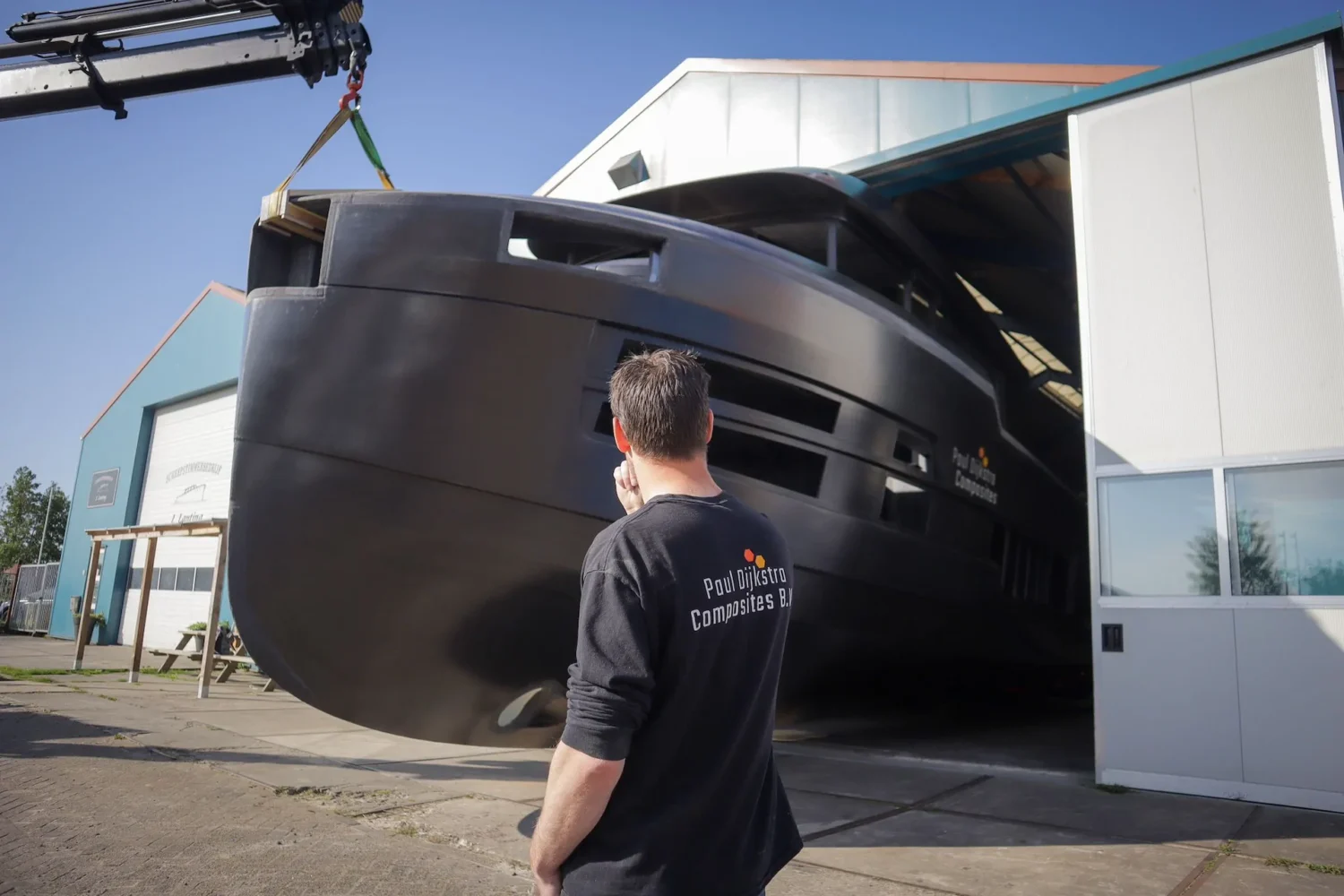 Medewerker kijkt naar een bootcasco bij de haldeur