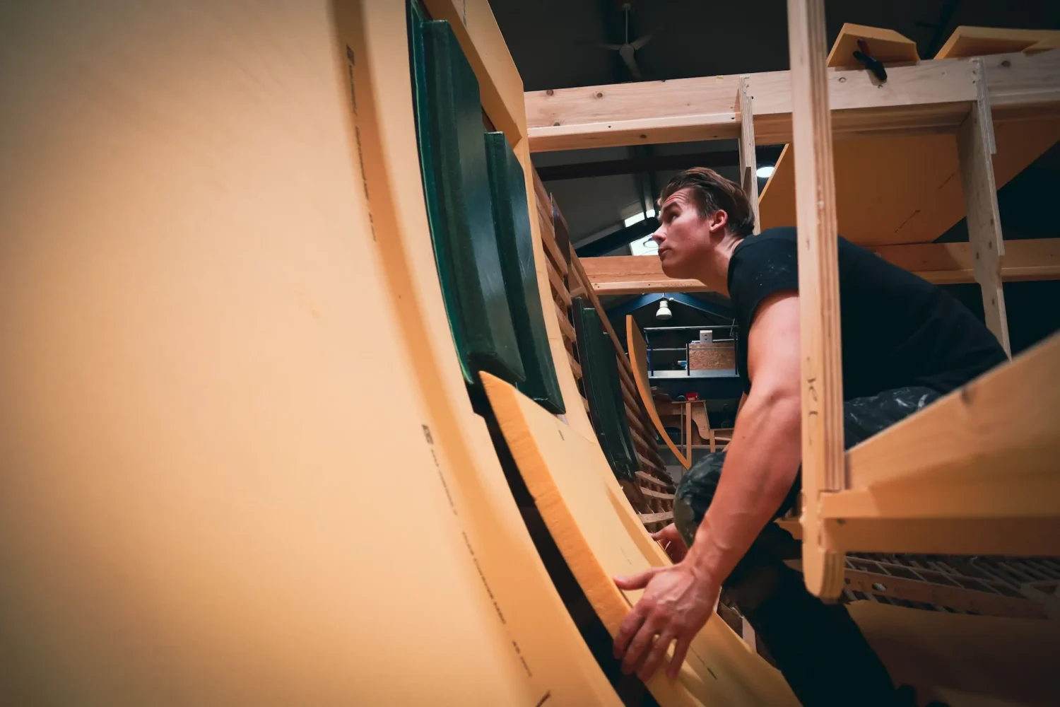 Medewerker aan het werk bij een houten bouwframe