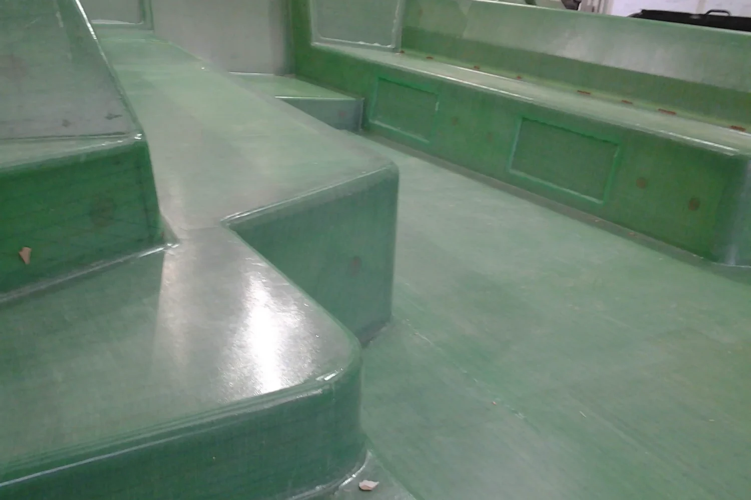 Detail van een groene composietconstructie met opstaande rand