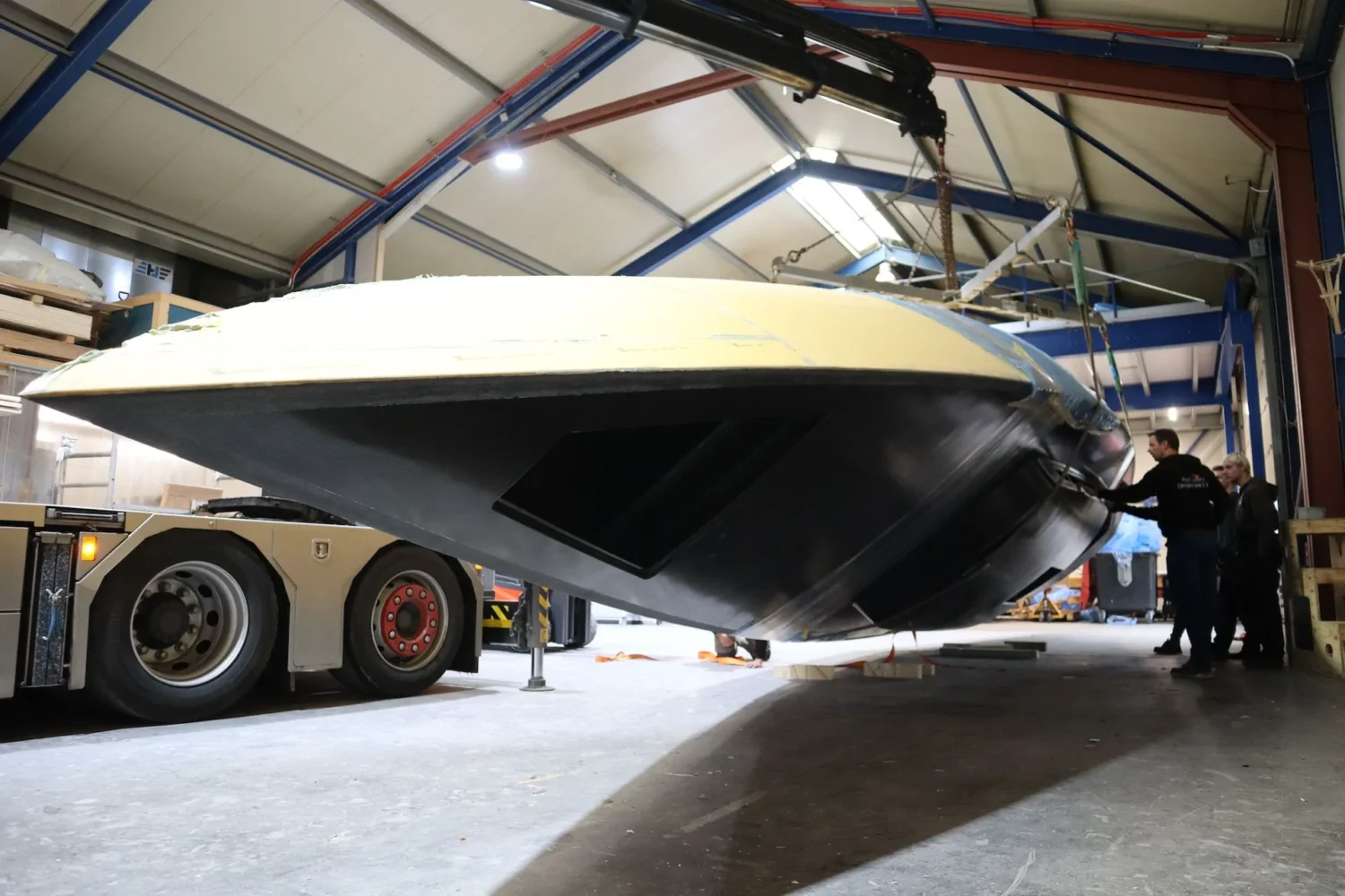Bootromp aan hijsbanden bij de werkplaatsdeur