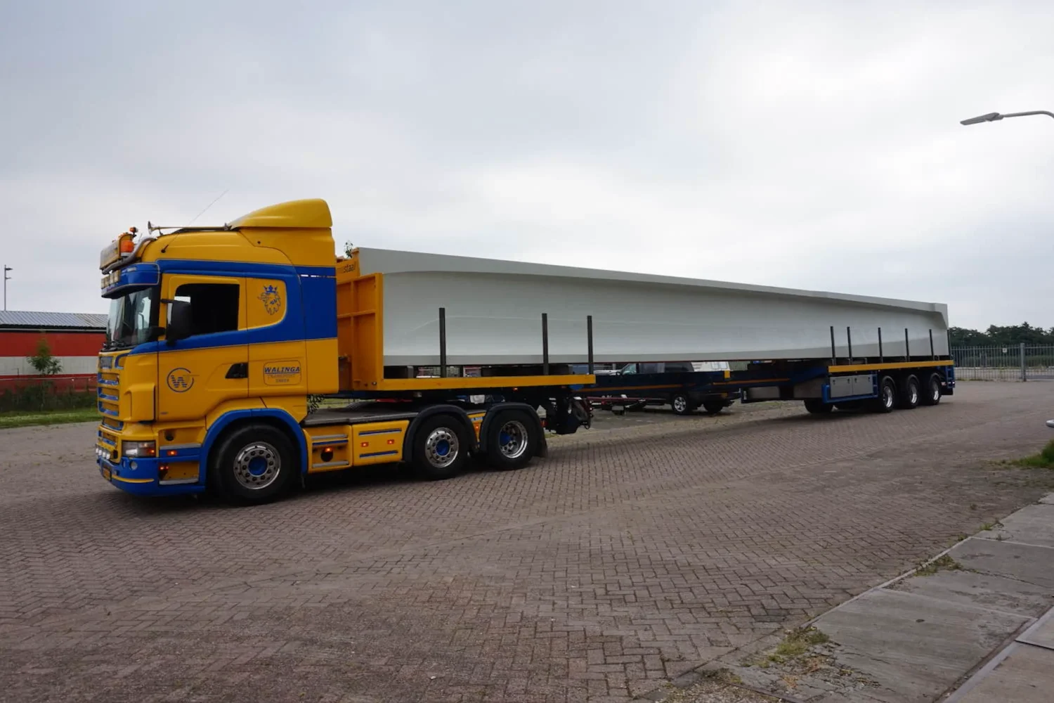 Vrachtwagen met lange lading op het terrein