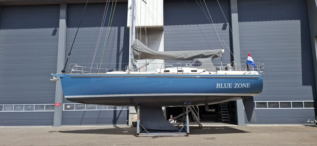 Blauw zeiljacht Blue Zone op steunen voor een loods