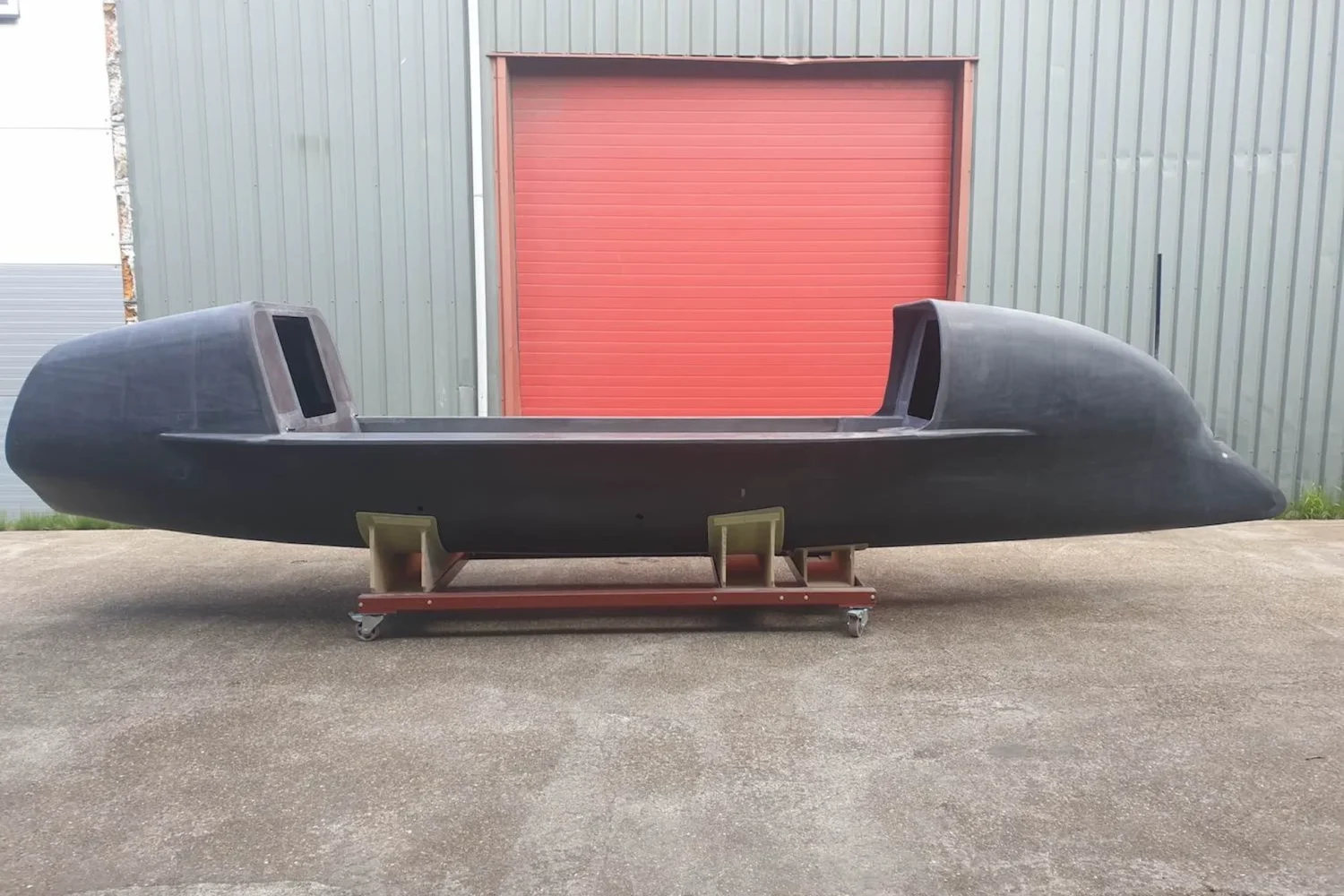 Zijaanzicht van een donkere roeiboot voor een roldeur