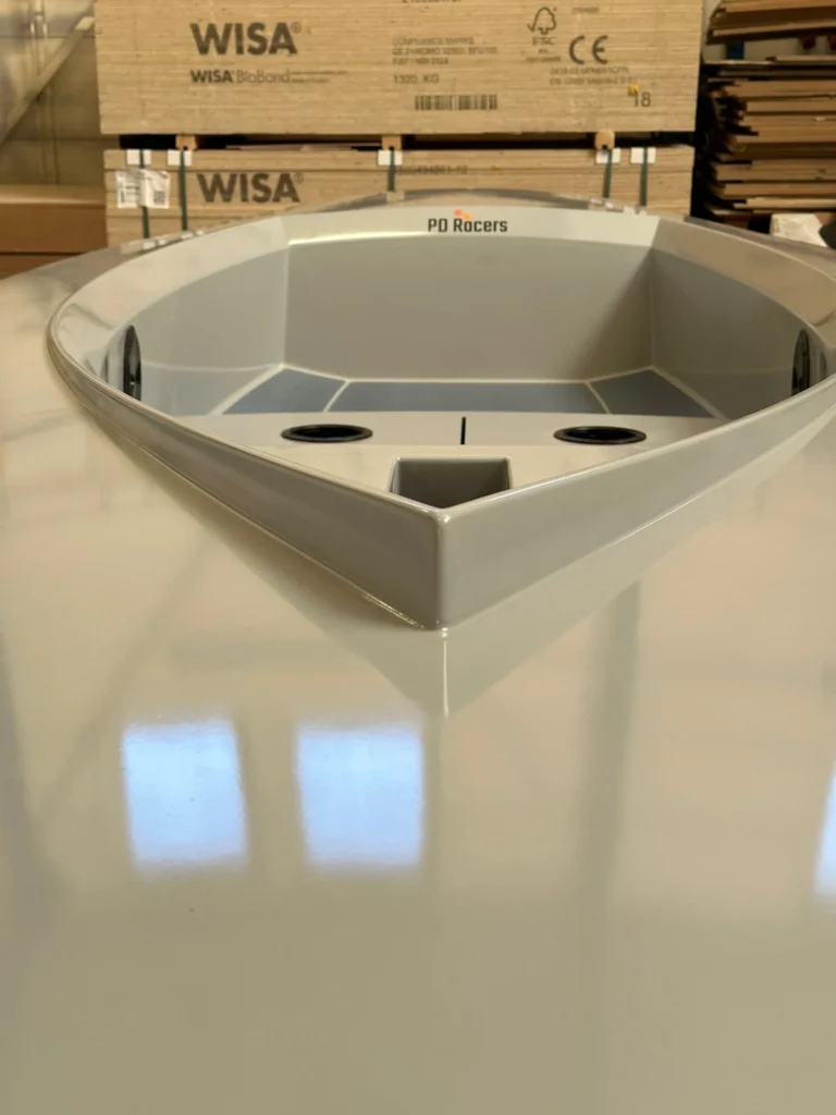 Witte kuip van een kleine zeilboot in de werkplaats