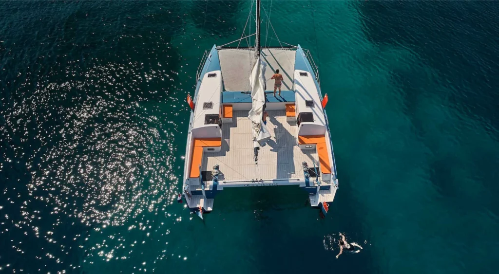 Catamaran van bovenaf op helderblauw water