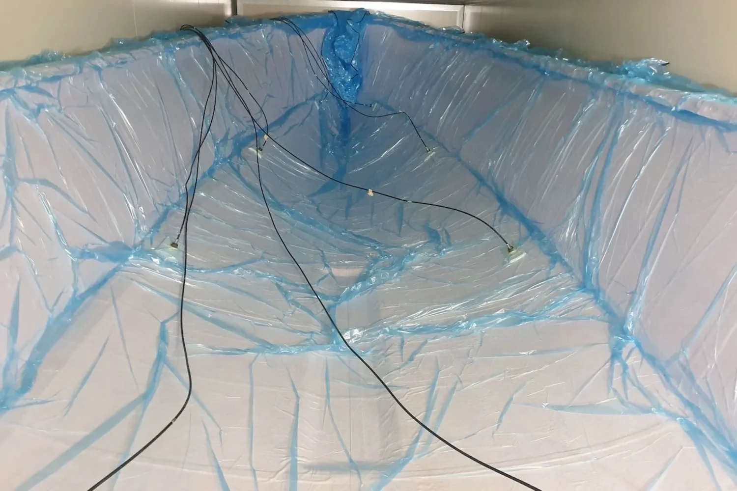 Blauw vacuümfolie en slangen over een rompconstructie